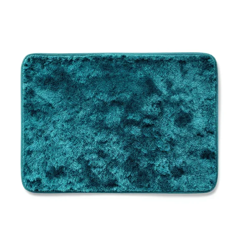 a plush teal bath mat, top-down view, single item fully visible and centred, isolated on a pu...