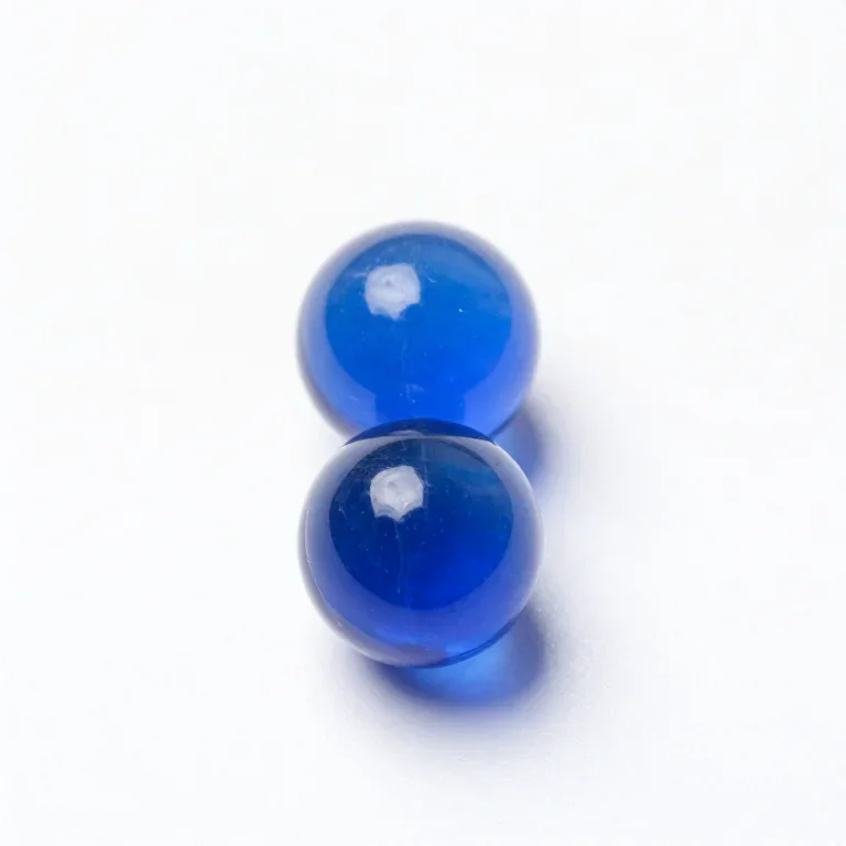 two blue glass marbles, top-down view, single item fully visible and centred, isolated on a p...