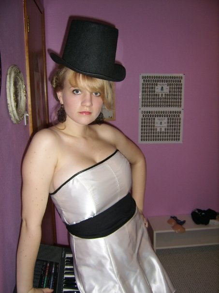 a cute woman in a white strapless dress and tophat