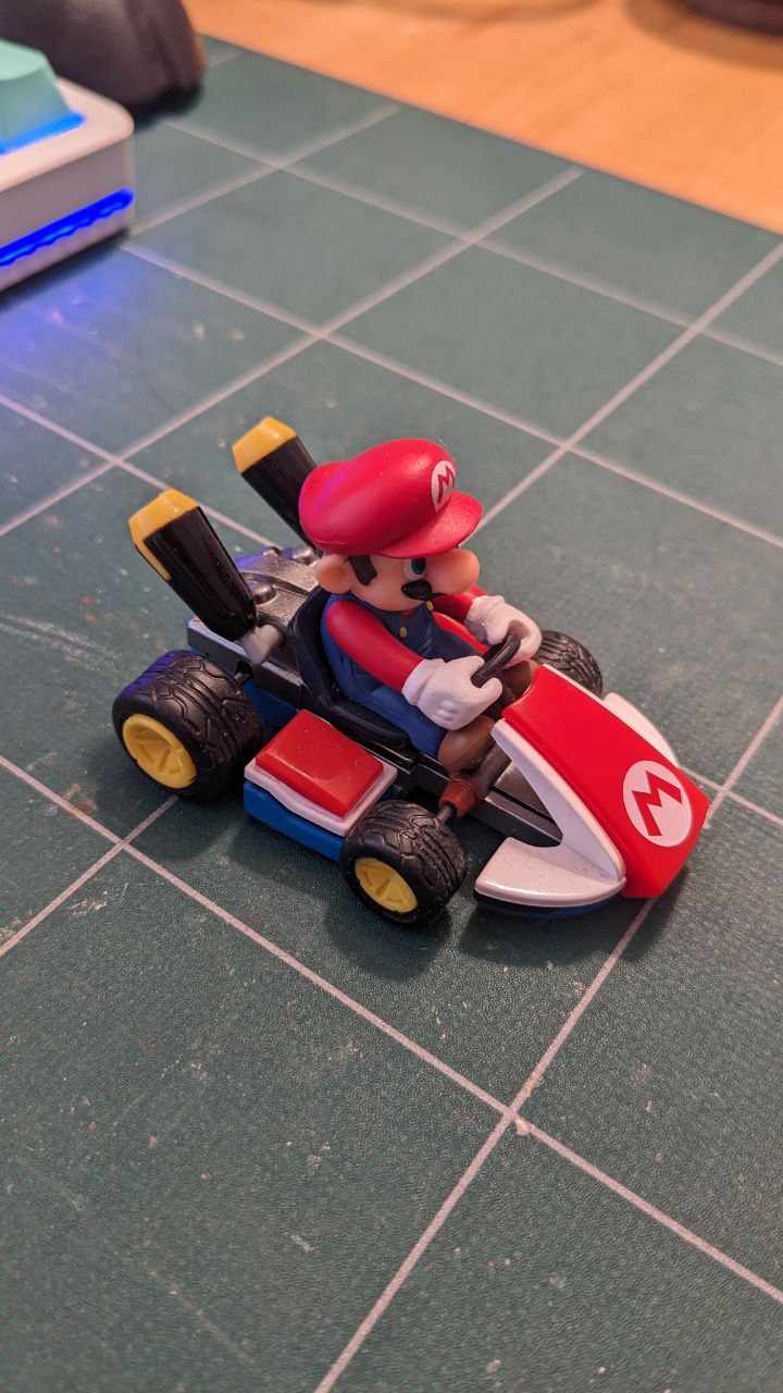 A plastic toy of Mario on Kart from MarioKart